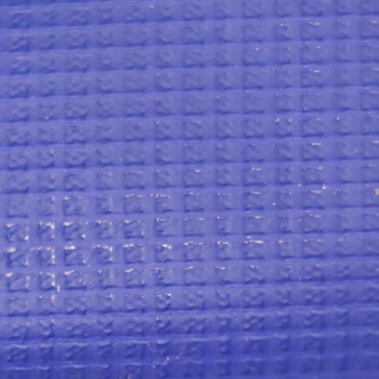 Close-up of 560gsm extra heavy PVC tarpaulin used for sheltering and protection.