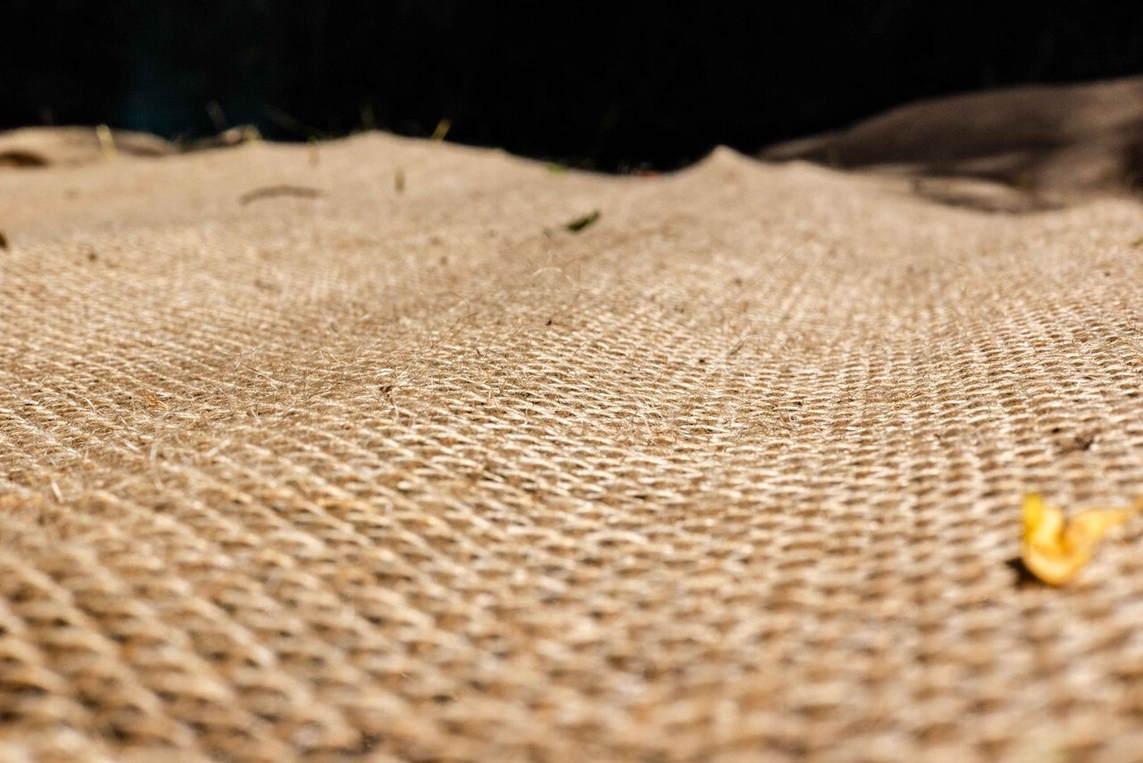 Rolls of hessian fabric showing coarse woven texture for crafting or industrial use.