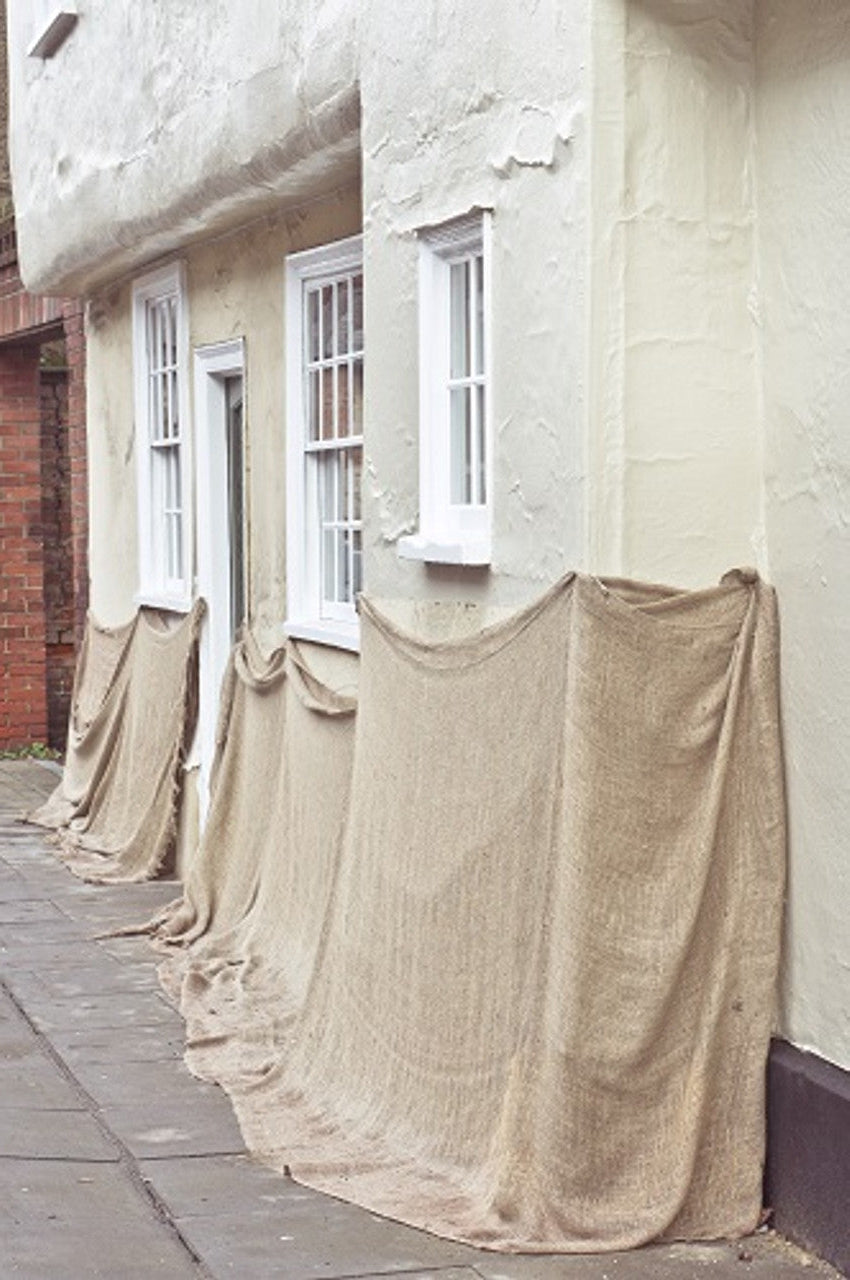 Rolls of hessian fabric showing coarse woven texture for crafting or industrial use.