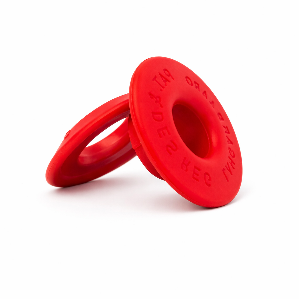 Small round plastic red eyelets arranged on a surface for crafting or industrial use.